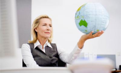 A businesswoman holds an inflatable globe
