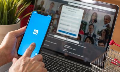 A saleswoman logs into LinkedIn on her smartphone