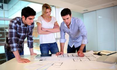 A group of architects looking over designs in their office