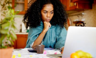 A female employee works remotely from her kitchen table