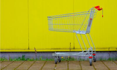 Abandoned shopping cart on yellow background Abandoned shopping cart on yellow background