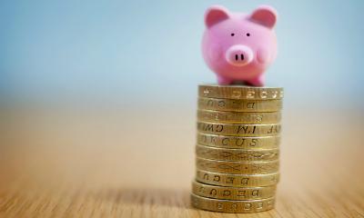 A piggy bank on a pile of coins