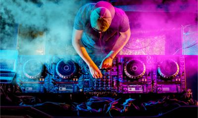 A professional DJ uses a high-end set of turntables equipment in a nightclub.