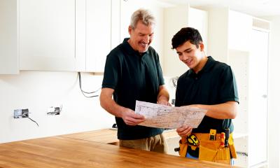 Builder holding plans of work to show a customer