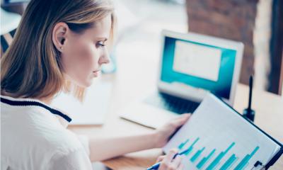A female business owner sits at her desk and carefully checks her budget