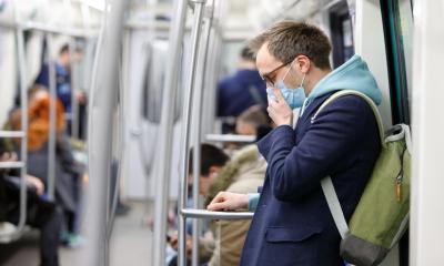 A male employee wears a face mask whilst communting to work to minimise the risk of contracting coronavirus