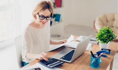 Happy accountant working with computer and calculator Happy accountant working with computer and calculator