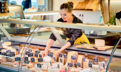 Cheese shop assistant serving a client