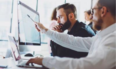 Two IT consultants analyse a computer system to identify faults