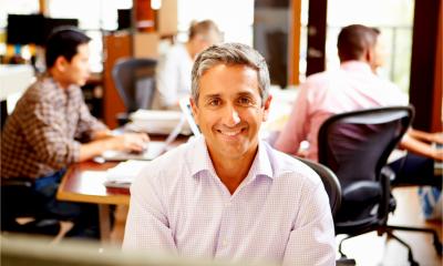 A business owner at work with employees working in the background