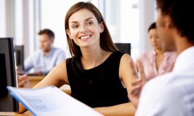 Inducting new employees - checklist Male office worker goes through induction checklist with female office worker