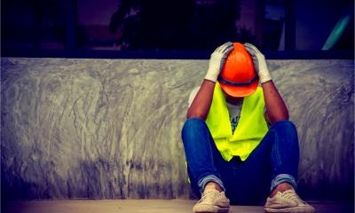 A building contractor holds his head in his hands