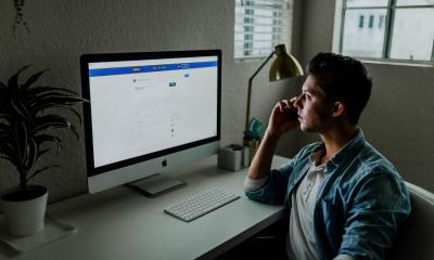 Businessman looking at computer screen while making a call