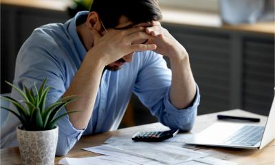 A distressed man worries about cash flow as a result of late payments