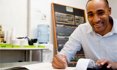 A café owner works on his accounts and calculates his cash flow and working capital.