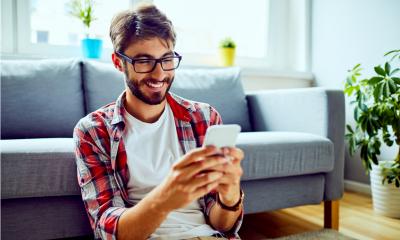 An attractive man earns money on his phone completing a survey