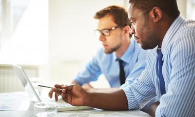 Management consultant pointing at a clients laptop with a pen