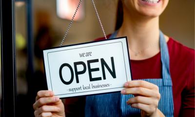 Small business owner turning the sign opening her business after the COVID-19 lockdown.