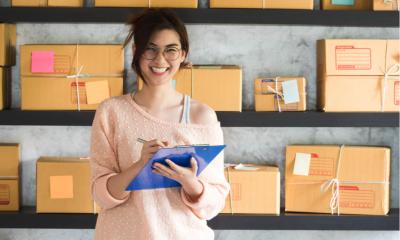 A new entrepreneur in her new logistics factory holding a checkboard