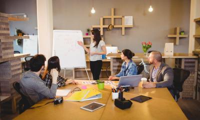 A team holds a business meeting around a conference table in a modern, stylish office.