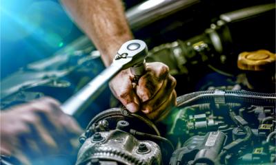 Auto mechanic working on car engine in mechanics garage