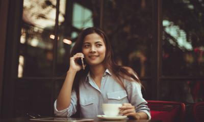 Portrait of young woman using mobile in a cafe