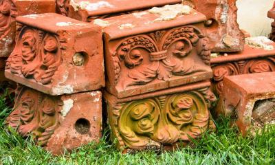Multiple brown bricks with patterns on them with grass underneath