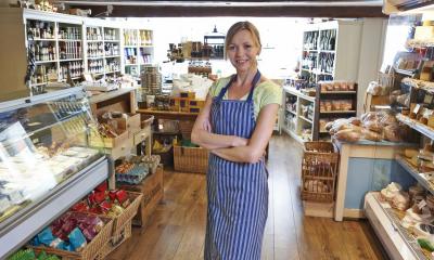 Woman in blue and white striped apron in delicatessen