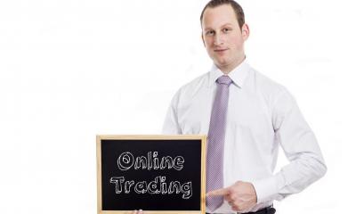 Man in white shirt pointing to text written on blackboard