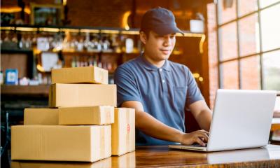 A small business owner checks his online orders and dispatches goods