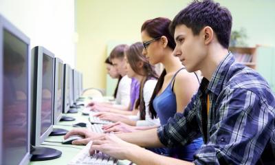 Multiple people sat down at computers in internet cafe