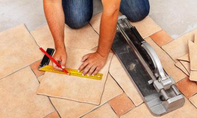 Man measuring and drawing on a tile to cut to shape
