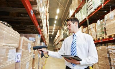Man in warehouse scanning packaged products on shelf