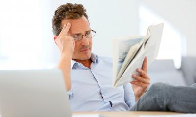 Business owner in glasses reading book about PR