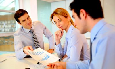 Group of people in blue shirts discussing a business plan