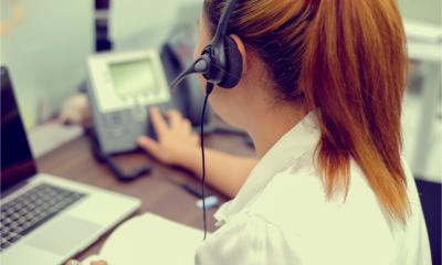 An office worker makes a phone call using a desk phone