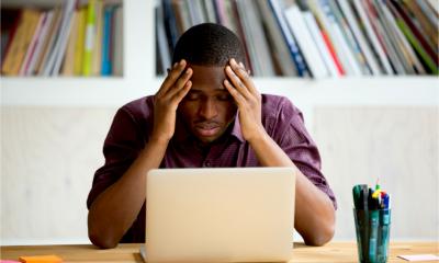 A man holds his head in his hands as he has forgotten his password