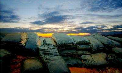 Wall of sandbags forming a defensive line against an approaching storm