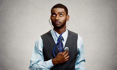 Male employee dressed smartly self-assessing himself with a stehoscope