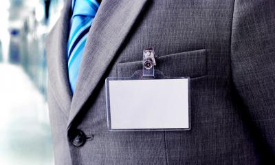 Close up of a business man wearing a suit with a blank name badge clipped to the pocket