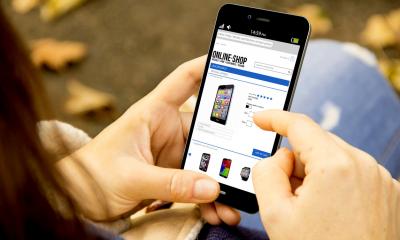 Woman using her phone to make an online purchase from an online selling phone shop