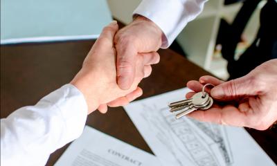 A man signs a commercial mortgage agreement and gets the keys to the property