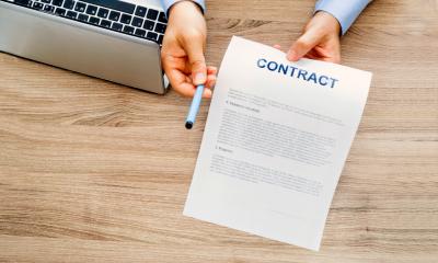 Overhead shot of an employer handing over a pen and an employment contract