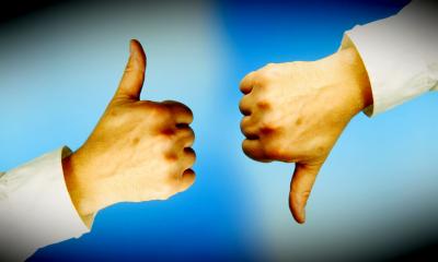 Two hands. One with a thumbs up and the other with thumbs down