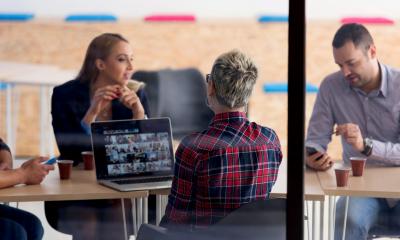 Work colleagues sitting together for a coffee in their glassed cafeteria