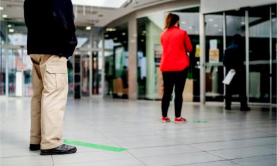 Customers maintain social distancing queuing to get into a shop after the coronavirus lockdown