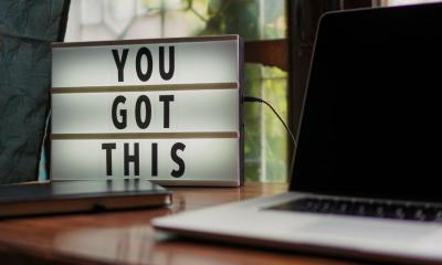 "YOU GOT THIS" motivational florescent board next to laptop