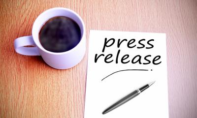 A cup of black copy next to a piece of paper saying press release