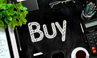 The word 'buy' on a tidy black desk