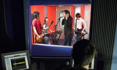 A band recording a single in a orange recording studio